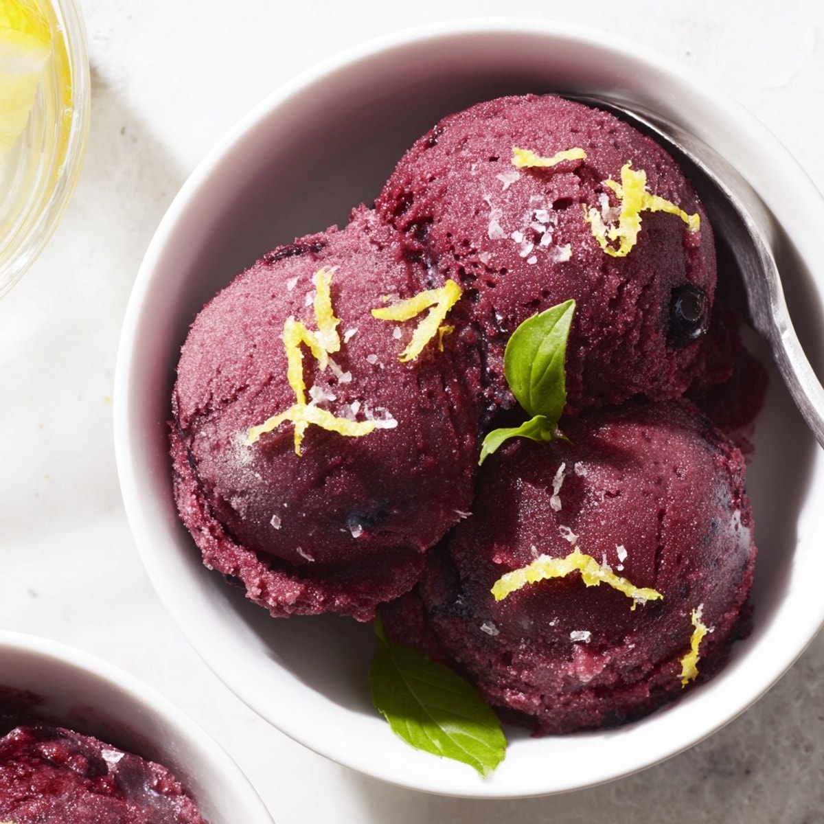 Close-up of vibrant, homemade Blueberry & Basil Lemonade Sorbet, ready to scoop.
