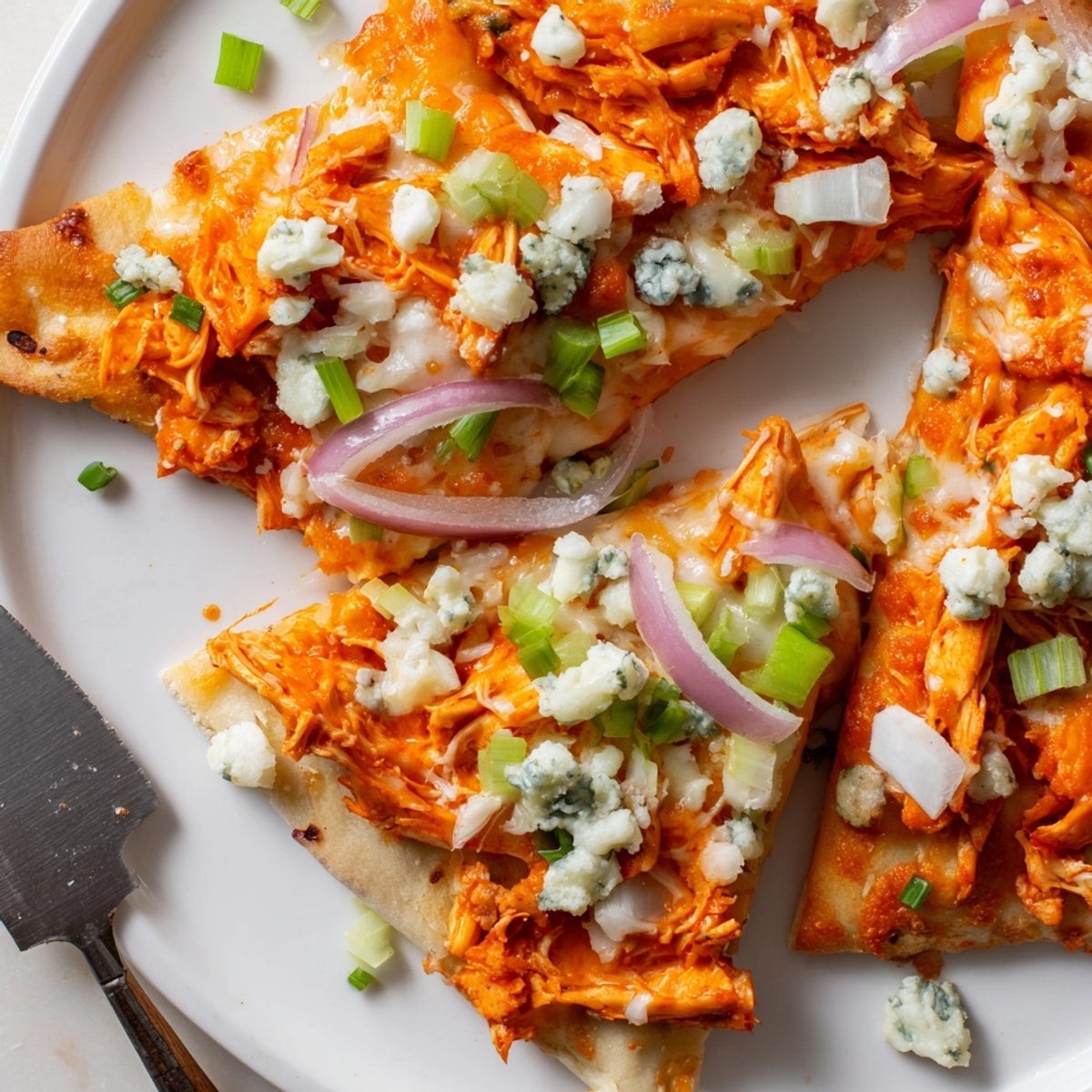 Spicy Buffalo Chicken and Blue Cheese Flatbread with creamy sauce, ready to slice.