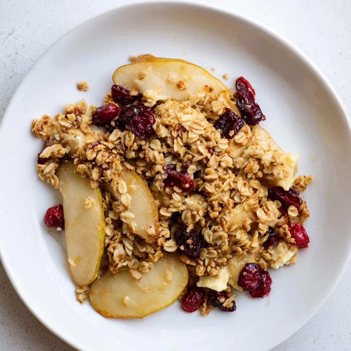 A close up shot of a Spiced Pear and Cranberry Crisp served steaming hot, ready to enjoy.