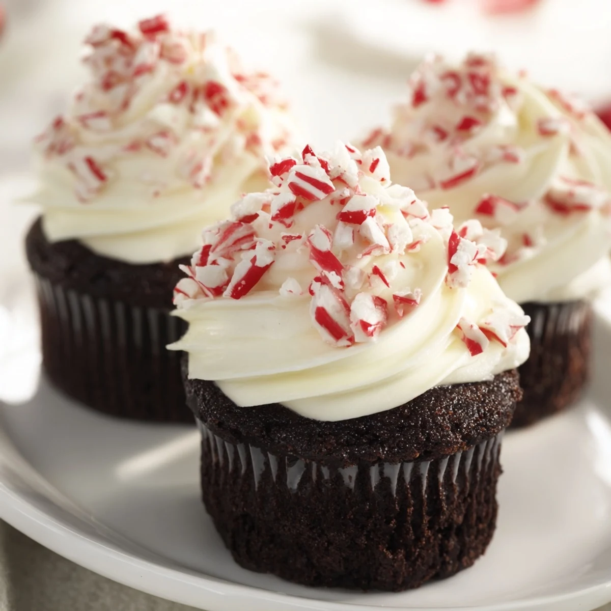 Frosted chocolate peppermint cupcakes, a delightful dessert with vibrant peppermint candy decorations.