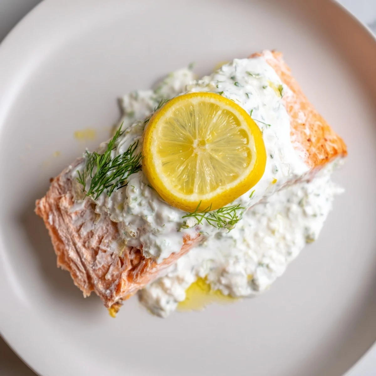 Flaky, baked salmon with lemon dill sauce, served and ready to be enjoyed with vibrant colors.