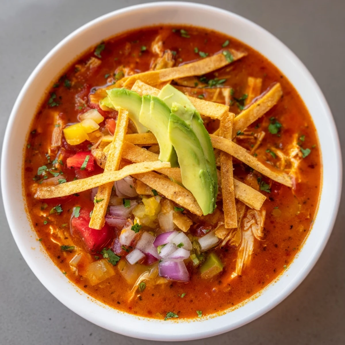 Steaming bowl of tortilla soup with colorful toppings, ready for a delicious Mexican meal.