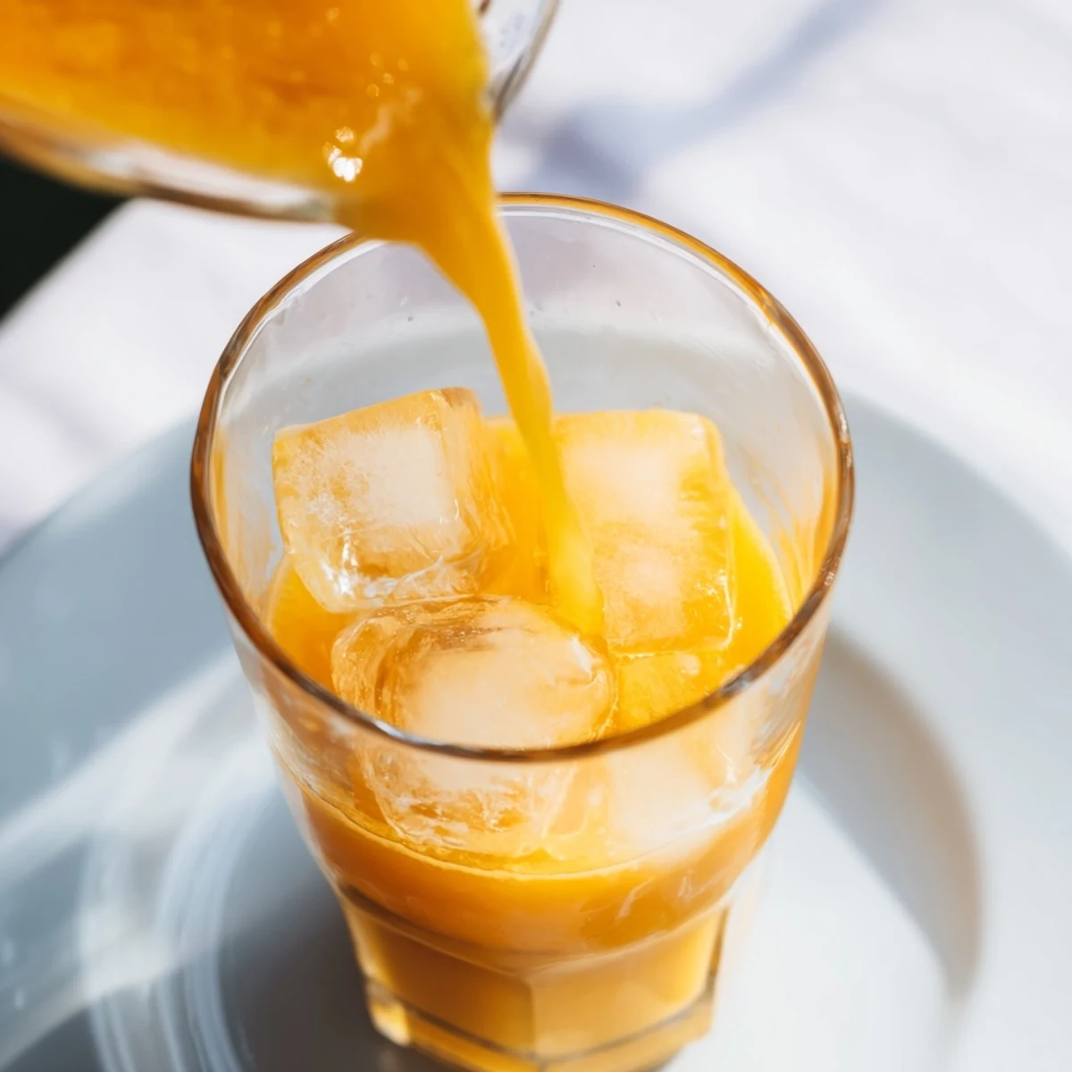 Vibrant fruit juice, a refreshing blend, served in clear glasses with ice and fresh fruit garnishes.