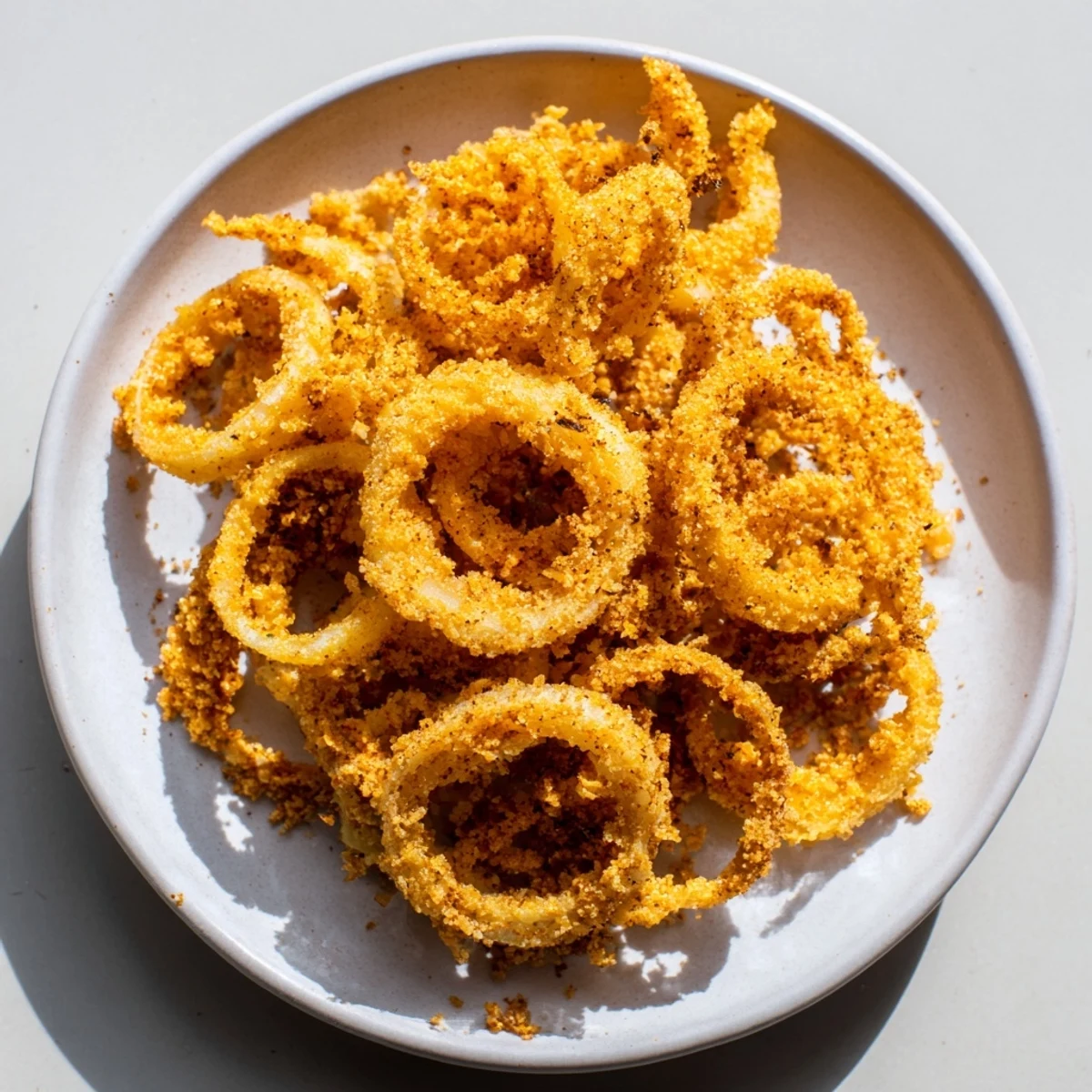 Golden brown, crispy onions topping a juicy burger, a tasty garnish in a photo.