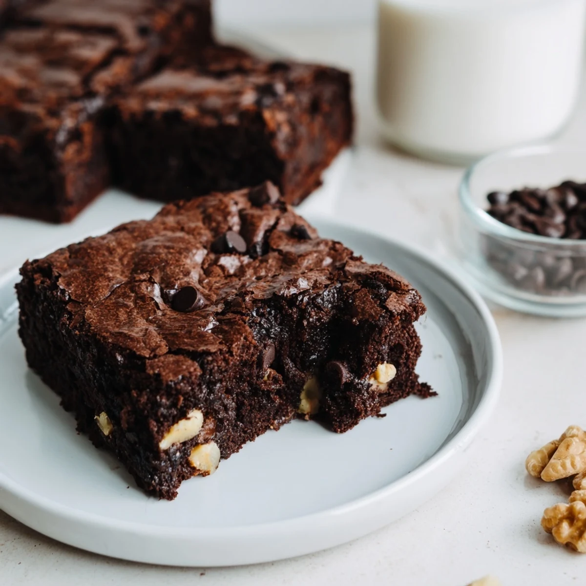 Warm chocolate brownies with a crackly top, glistening and ready to cut and serve.