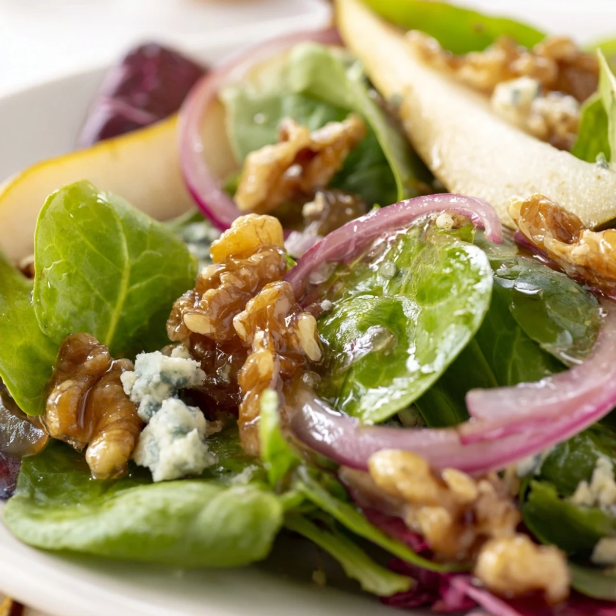 Freshly sliced ripe pears and candied walnuts atop a vibrant bed of mixed winter greens, drizzled with tangy vinaigrette.