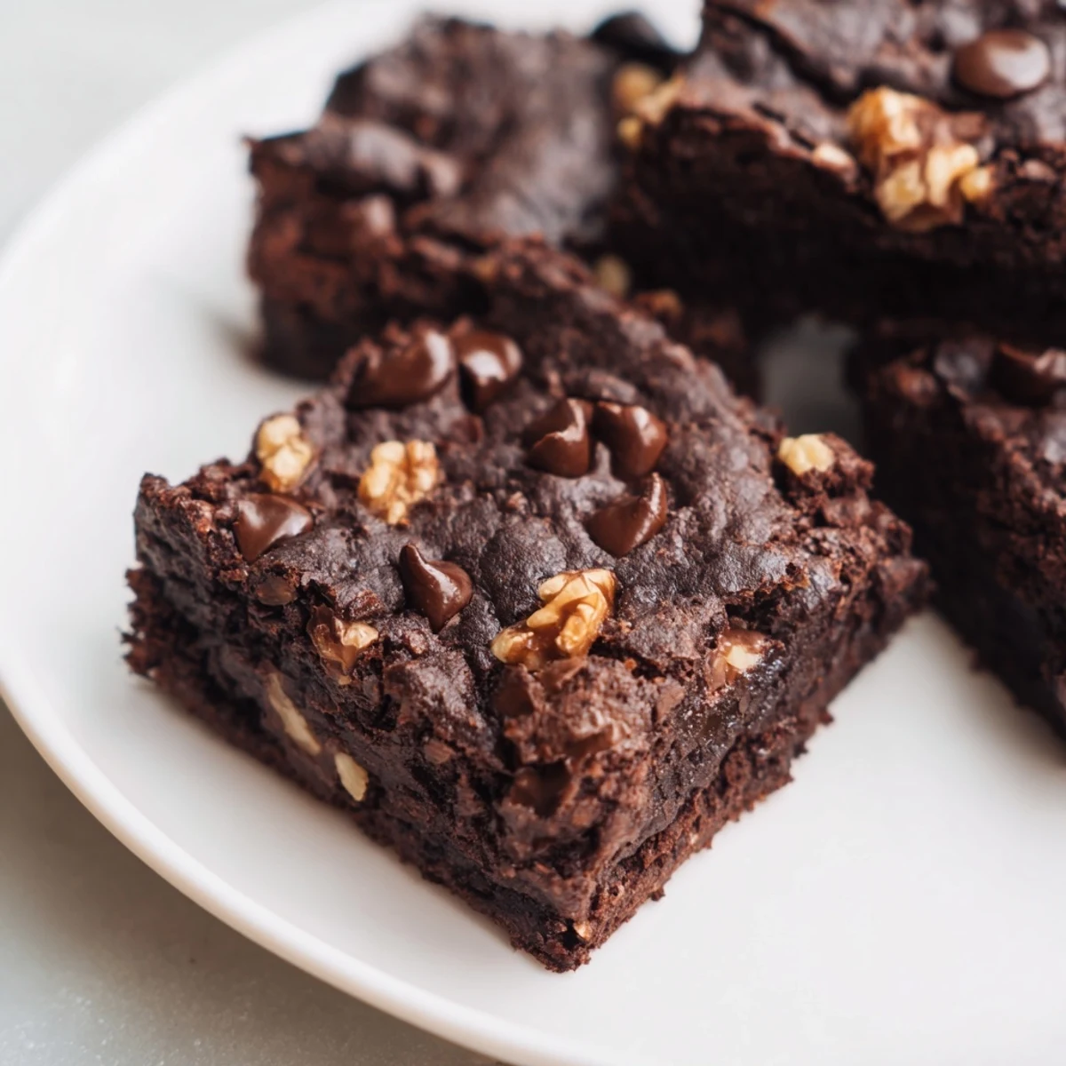 Close-up texture shot of warm Chocolate Fudge Brownies with Walnuts, highlighting the crackly top and moist, dense crumb.