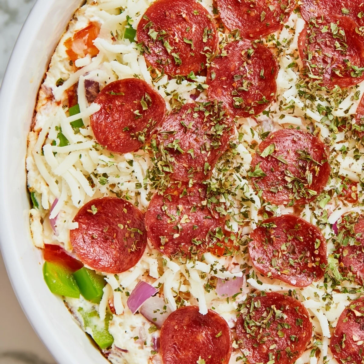 Golden, bubbling Game Day Pepperoni Pizza Dip with beef pepperoni and melted cheese in a baking dish, ready to serve with toasted bread.