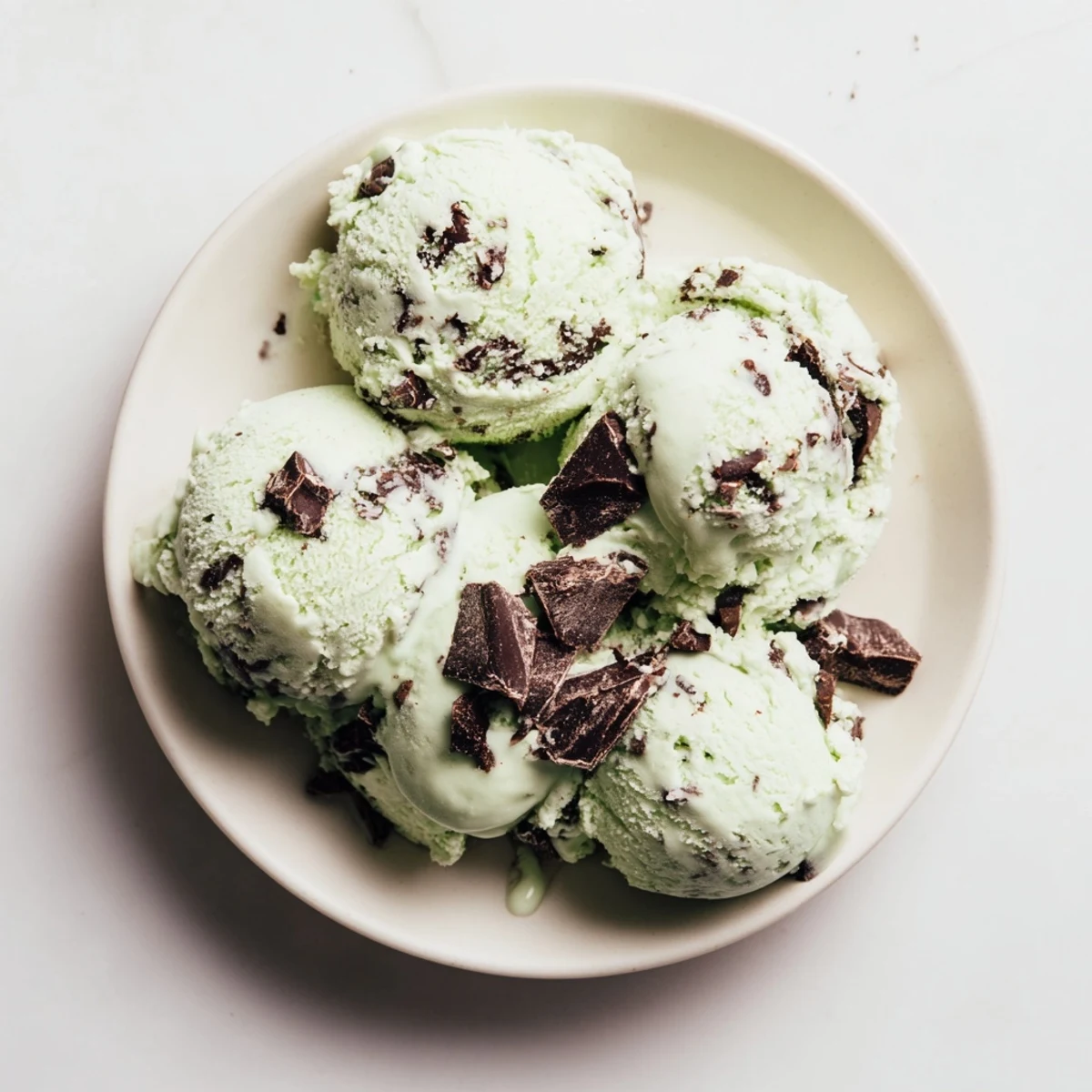 Festive St. Patricks Day Mint Chocolate Chip Ice Cream in a waffle cone, sprinkled with chocolate shavings and mint leaves.