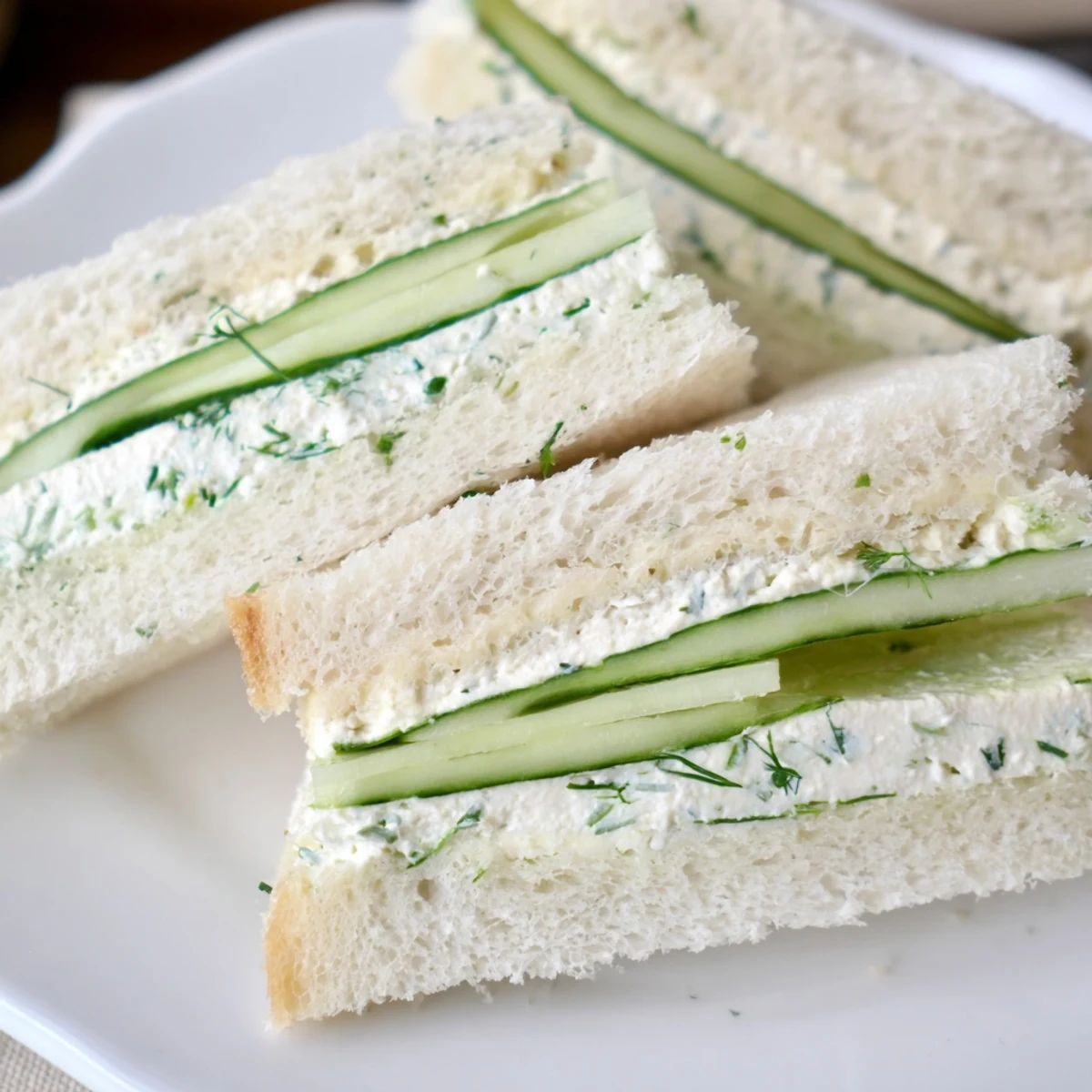 Freshly prepared Cucumber Sandwiches with Herb Cream Cheese arranged on a wooden board, perfect for elegant tea parties or light summer appetizers.
