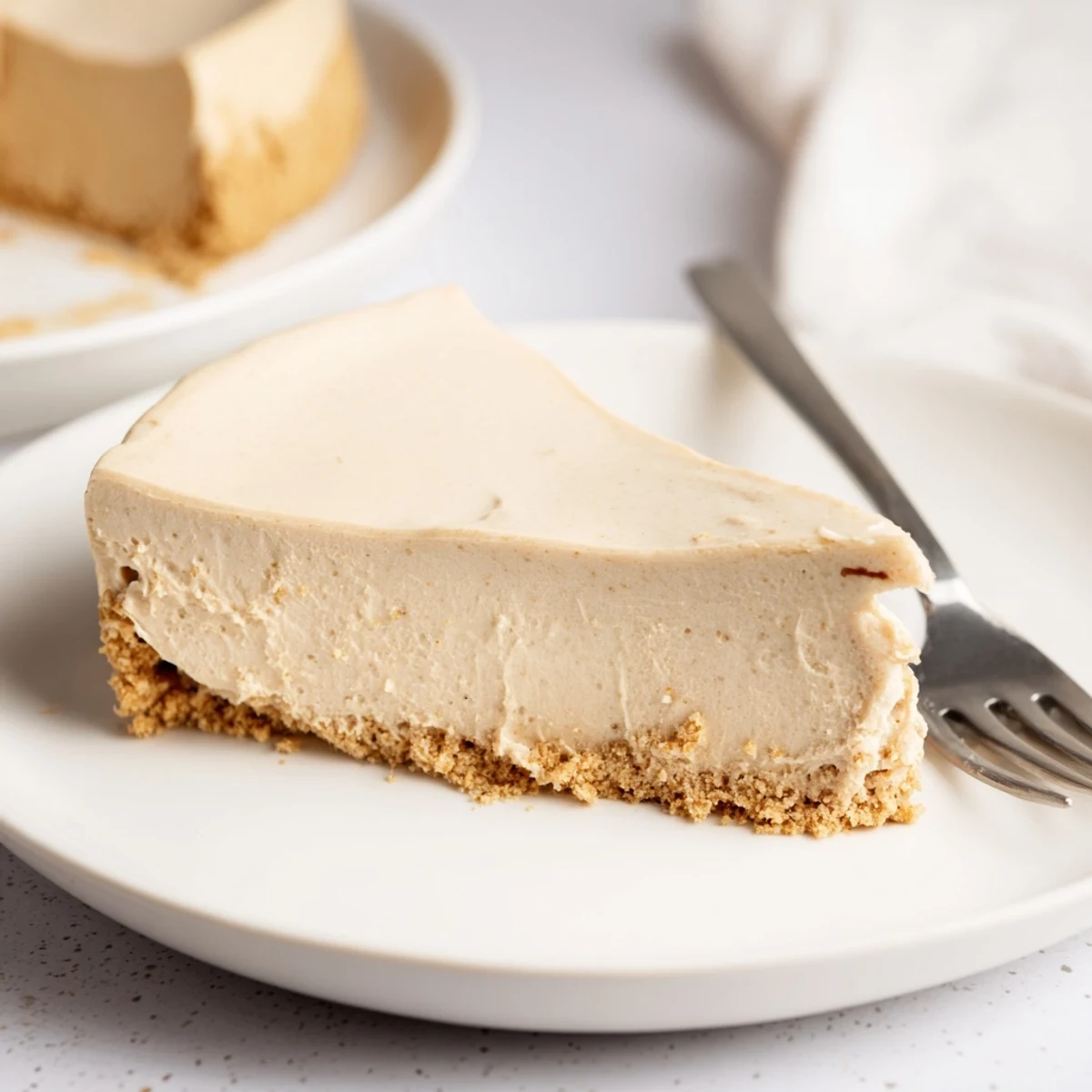 Creamy, no-bake Irish Cream Cheesecake topped with whipped cream and chocolate curls on a rustic table.