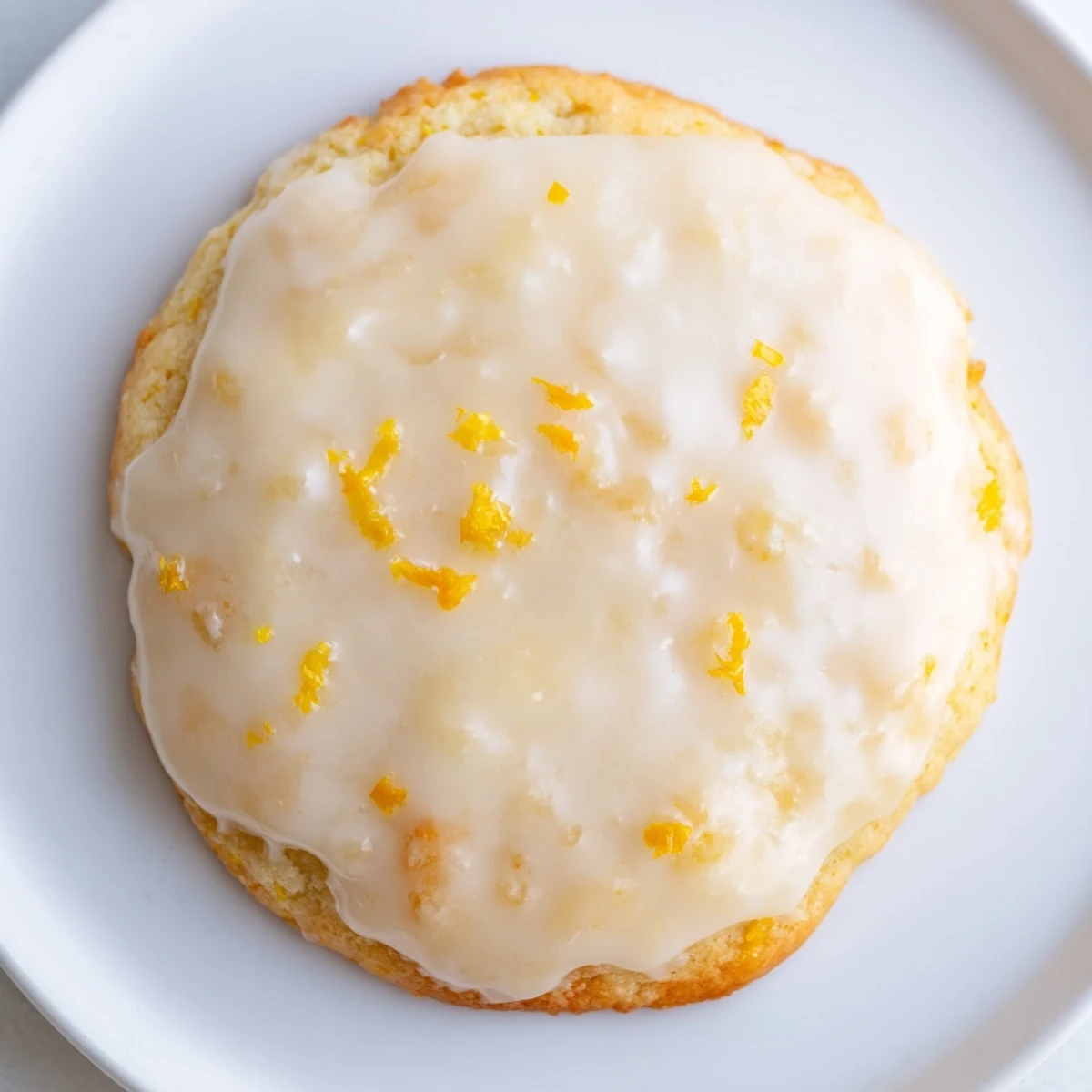 Lemon Ricotta Cookies with Lemon Glaze sit on a wire rack, glistening and ready to serve with tea.