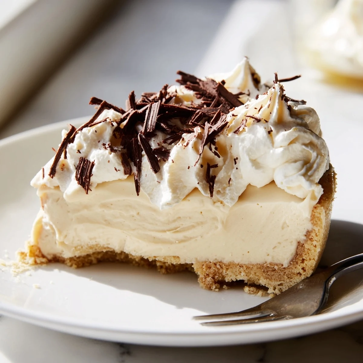 Freshly baked Irish Cream Cheesecake with a buttery biscuit crust and a rich, creamy filling on a marble counter.