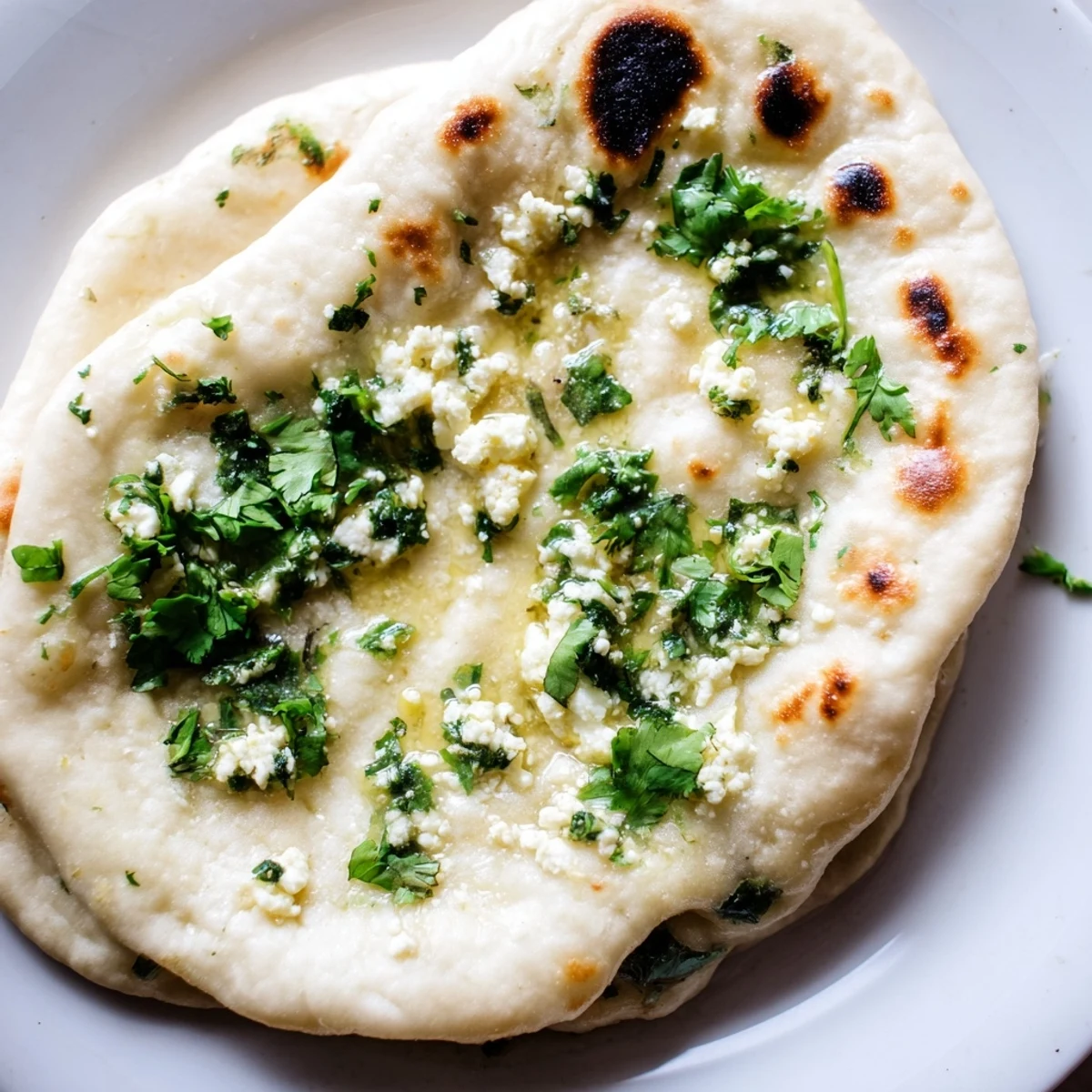 Golden-brown Cottage Cheese Garlic Naan stacked on a wooden board, revealing soft, pillowy texture and melted cottage cheese filling for a cozy meal.