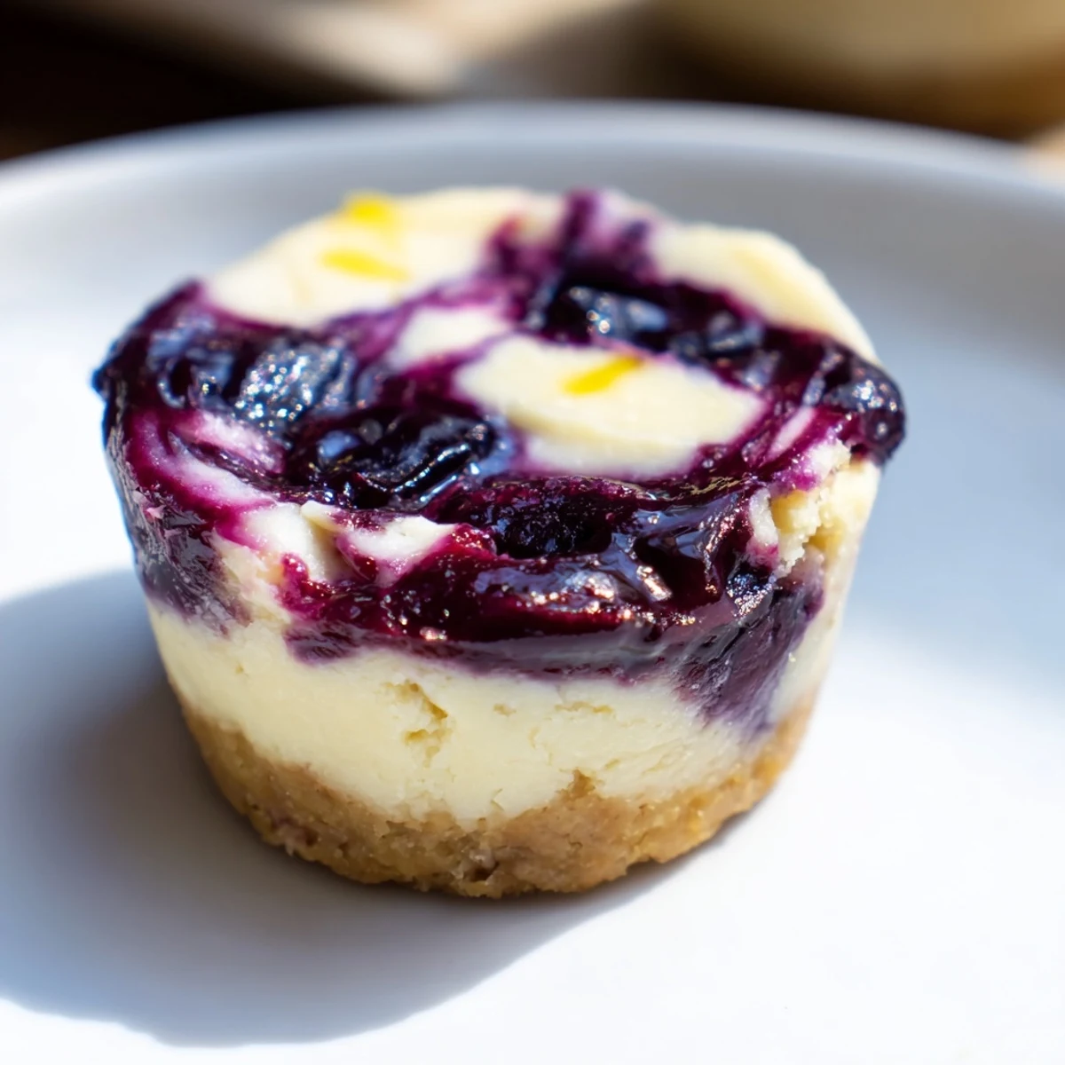 A close-up of homemade blueberry cheesecake protein bites highlights the smooth texture and vibrant purple swirl.