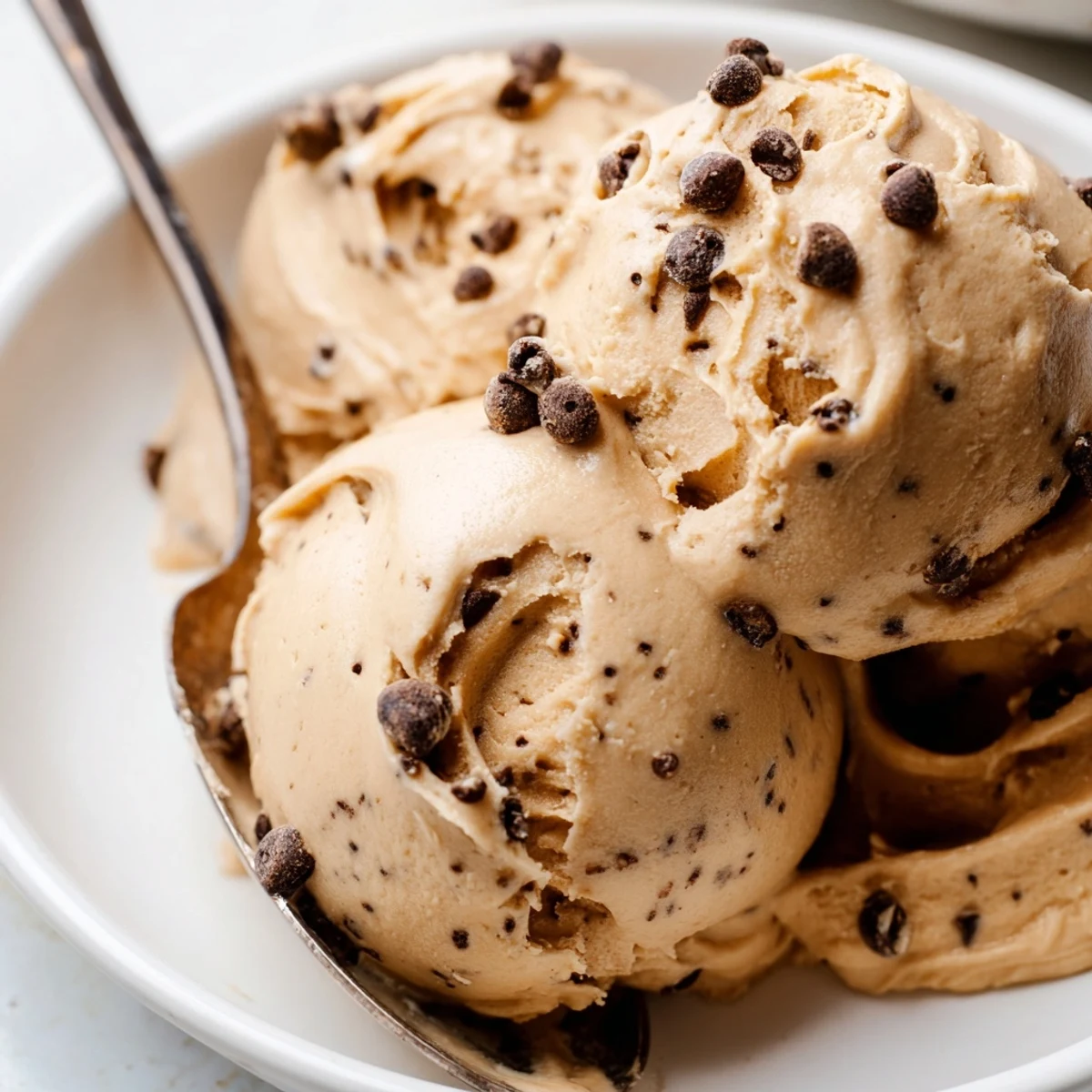 This Cookie Dough Frosting swirled on a cupcake has edible chocolate chips and a soft texture.