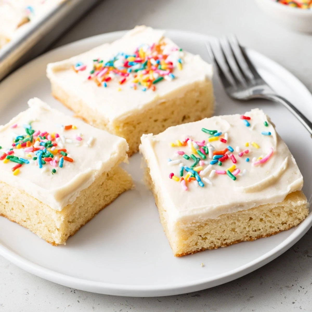 A square pan of freshly baked Sugar Cookie Bars with creamy frosting, cut into neat pieces ready to serve at a family celebration.