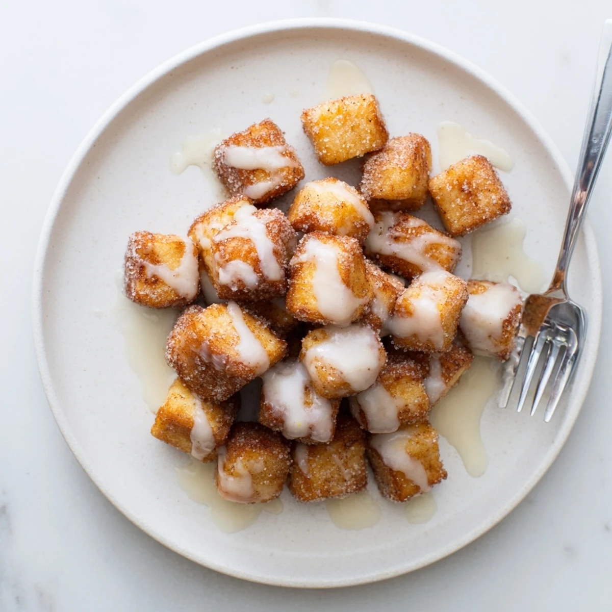 Warm Cinnamon Roll French Toast Bites stacked high, ready for maple syrup drizzle.