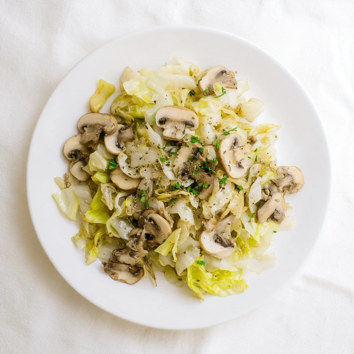 Steaming Vegetarian Cabbage Mushroom Sauté served alongside a fork and a rustic slice of whole grain bread.