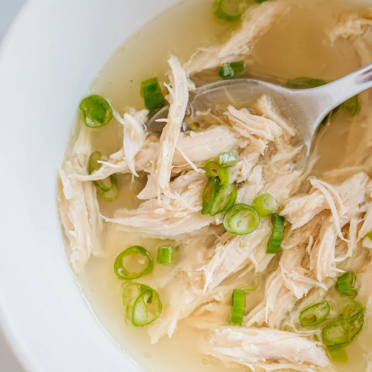 Nourishing Dakgomtang Korean chicken soup featuring clear aromatic broth, pulled chicken pieces, and sesame seed topping
