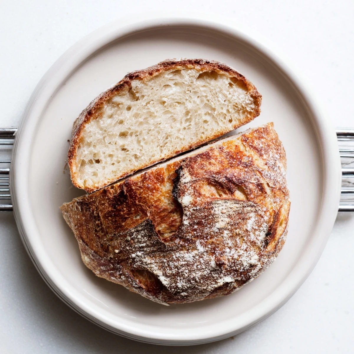 Freshly baked artisan no knead bread broken into pieces showing tender crumb and crispy exterior