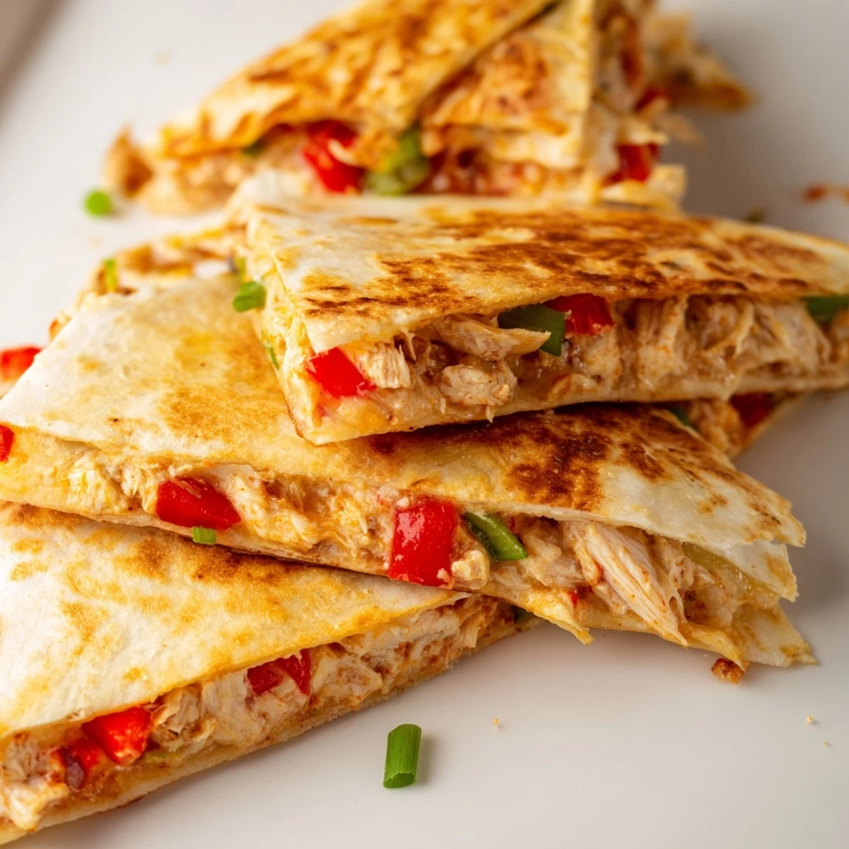 Crispy oven-baked quesadillas stuffed with seasoned shredded chicken and vegetables on a wooden board