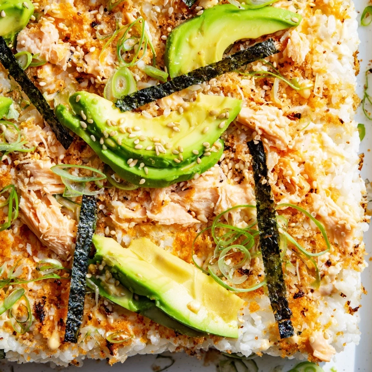 Warm deconstructed salmon sushi bake casserole with fluffy rice and fresh green onion garnish