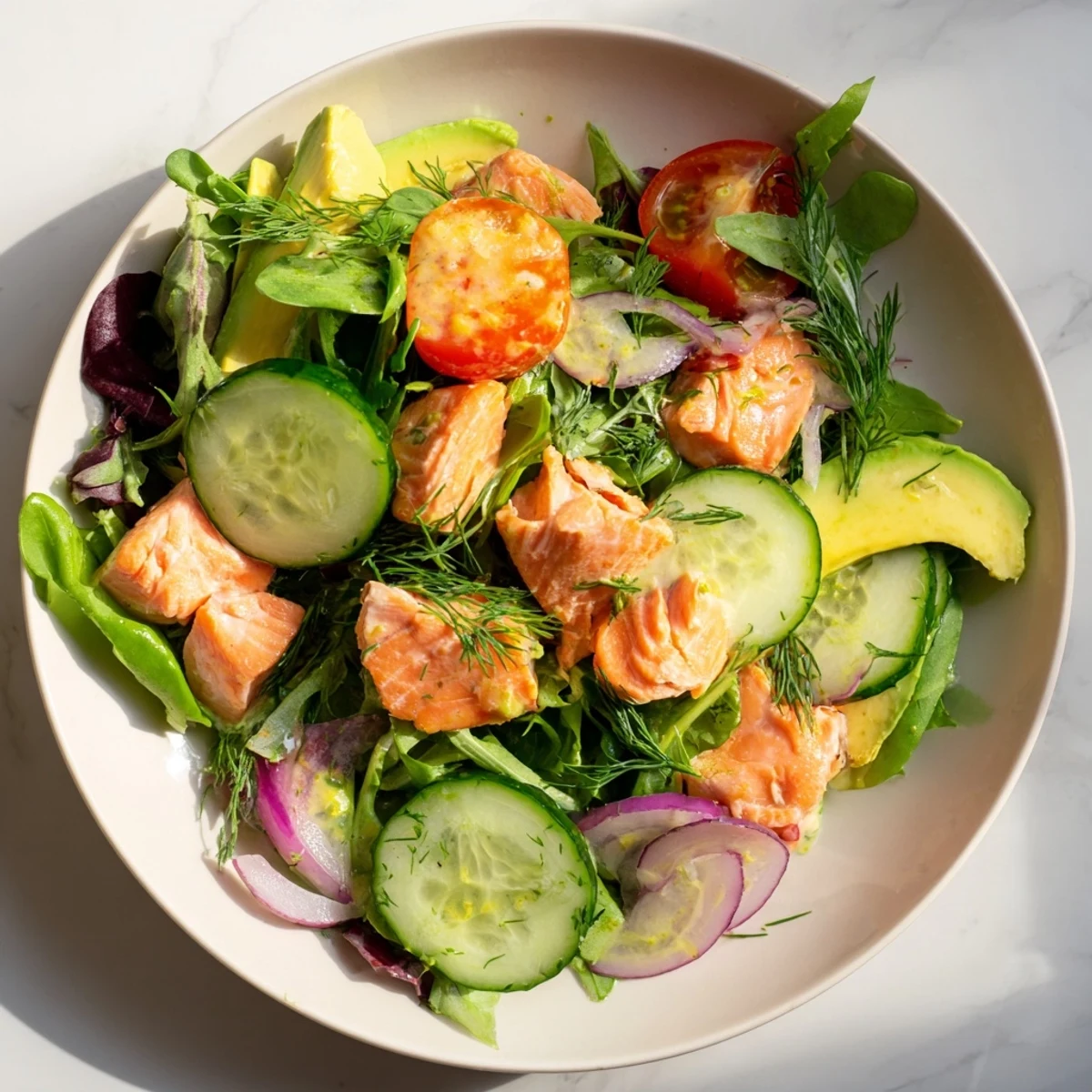 Flaked salmon fillets tossed with crisp mixed greens, avocado, cherry tomatoes, and cucumber in a light lemon honey dressing.