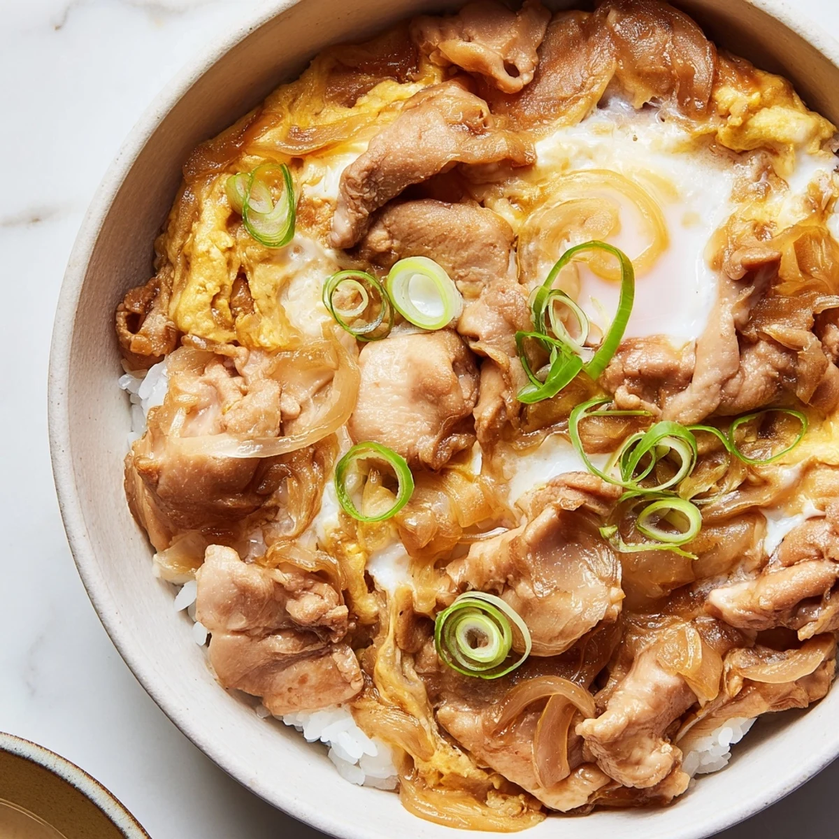 Homemade Oyakodon bowl featuring fluffy eggs and tender chicken over steamed white rice