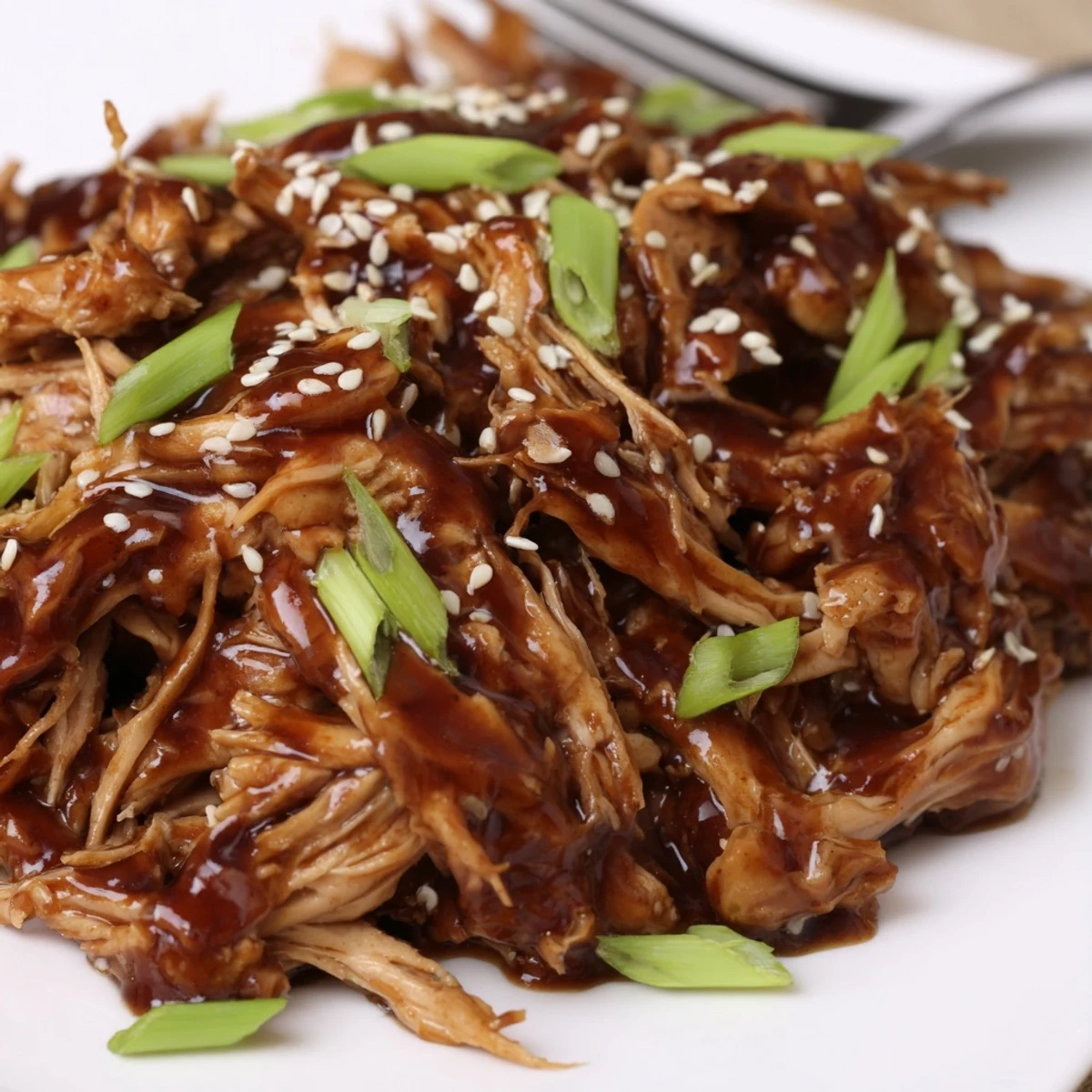Slow cooker Crockpot Teriyaki Chicken featuring tender shredded meat coated in glossy homemade teriyaki glaze