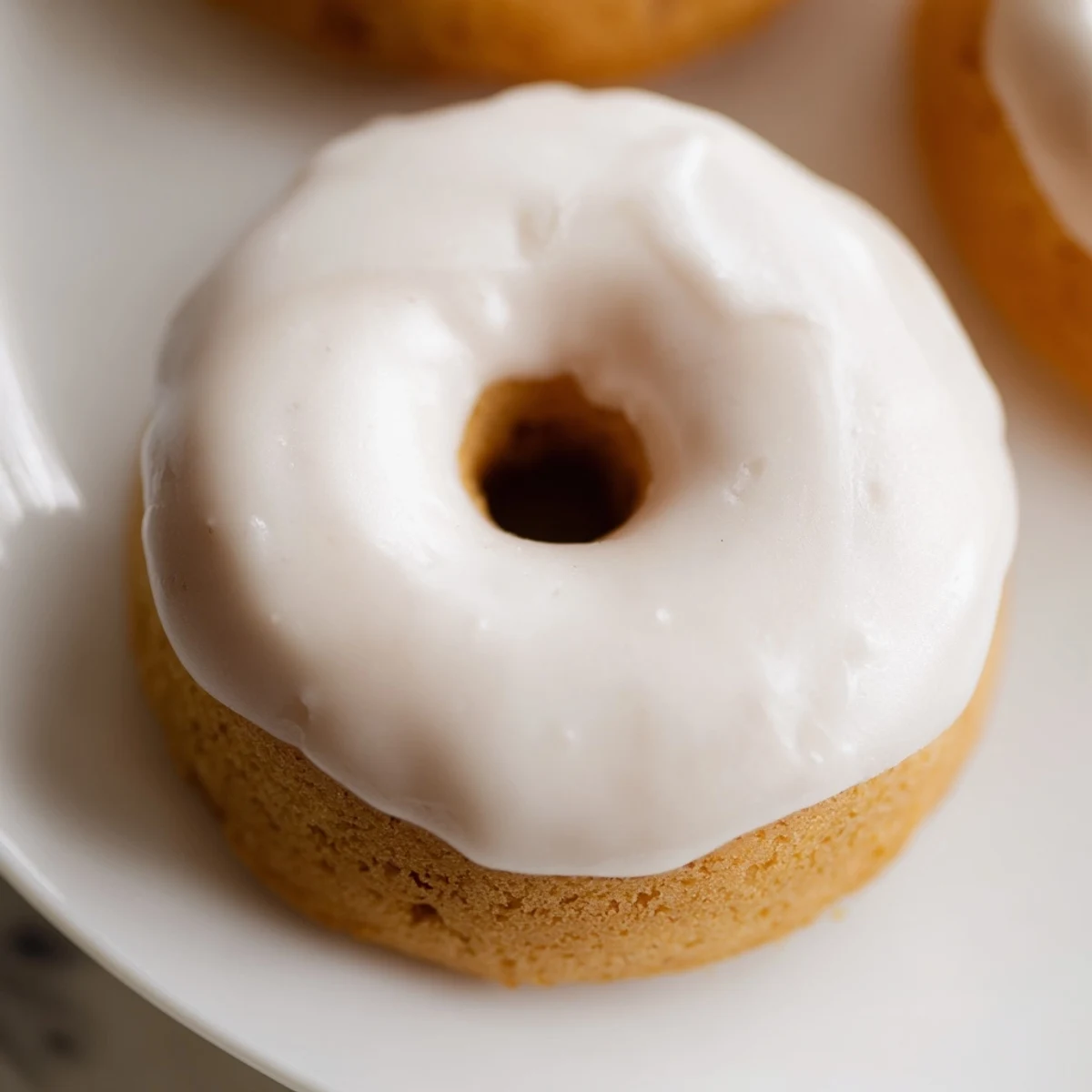 Golden baked Greek yogurt cake donuts topped with sweet vanilla glaze and sprinkles