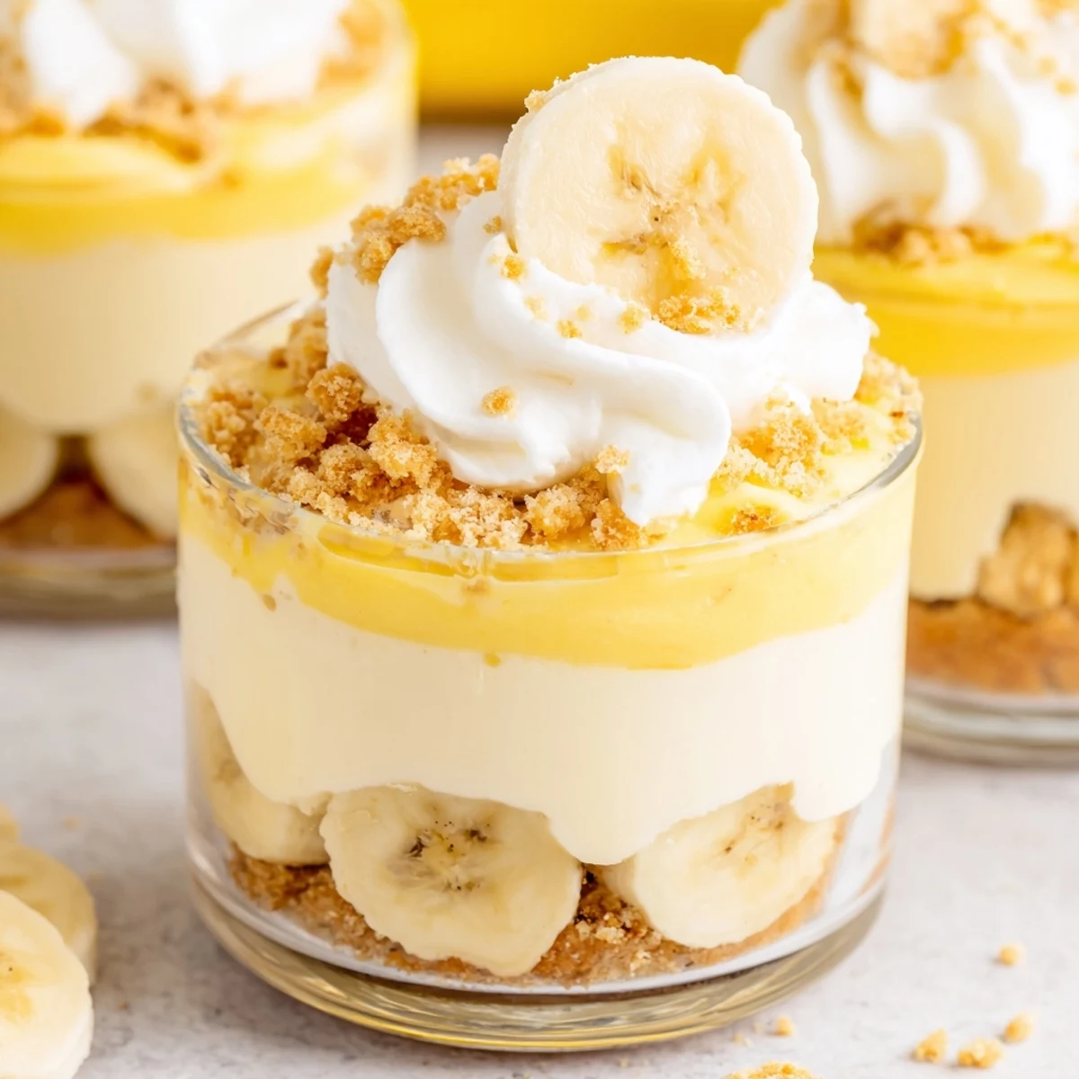 Creamy banana pudding cheesecake cups layered with fresh banana slices and vanilla wafer crumbs