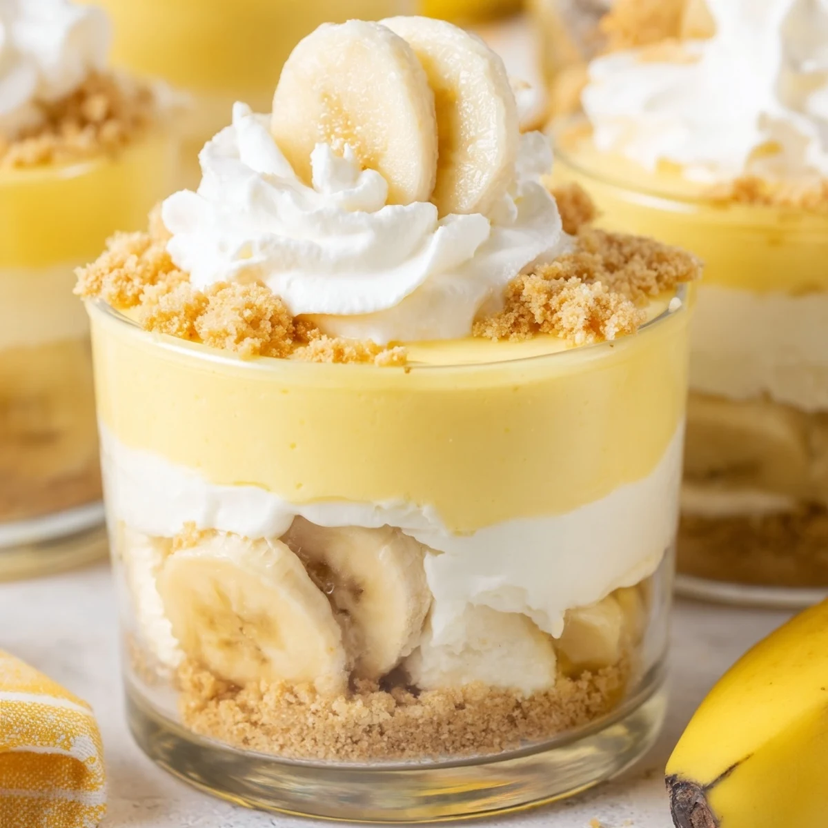 No bake banana pudding cheesecake cups with fluffy cheesecake filling topped with golden cookie crumbs