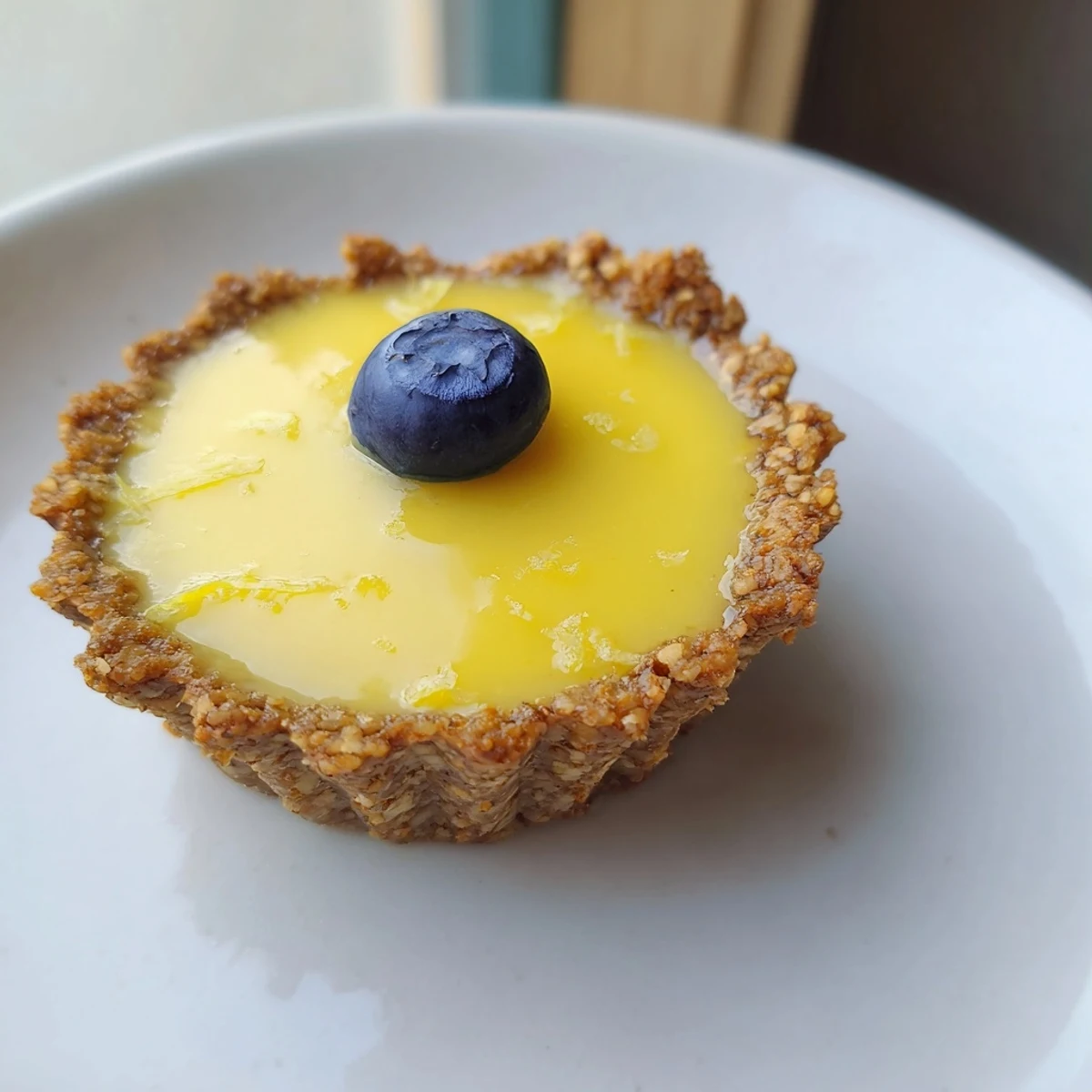 Creamy vegan lemon tarts in crisp almond crusts dusted with powdered sugar