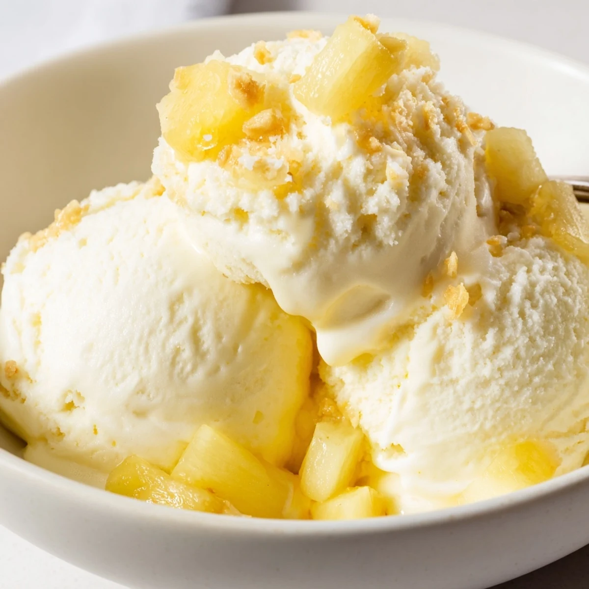 Homemade Creamy Pineapple Ice Cream churned smooth, flecks of fresh pineapple