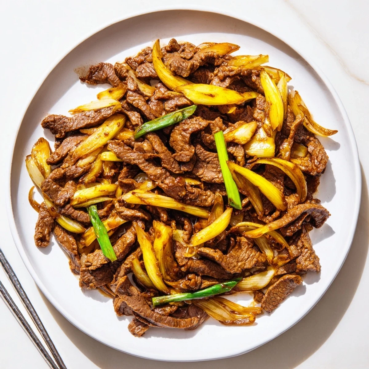 Savory Chinese stir fry featuring caramelized onions and tender crispy beef in glossy sauce