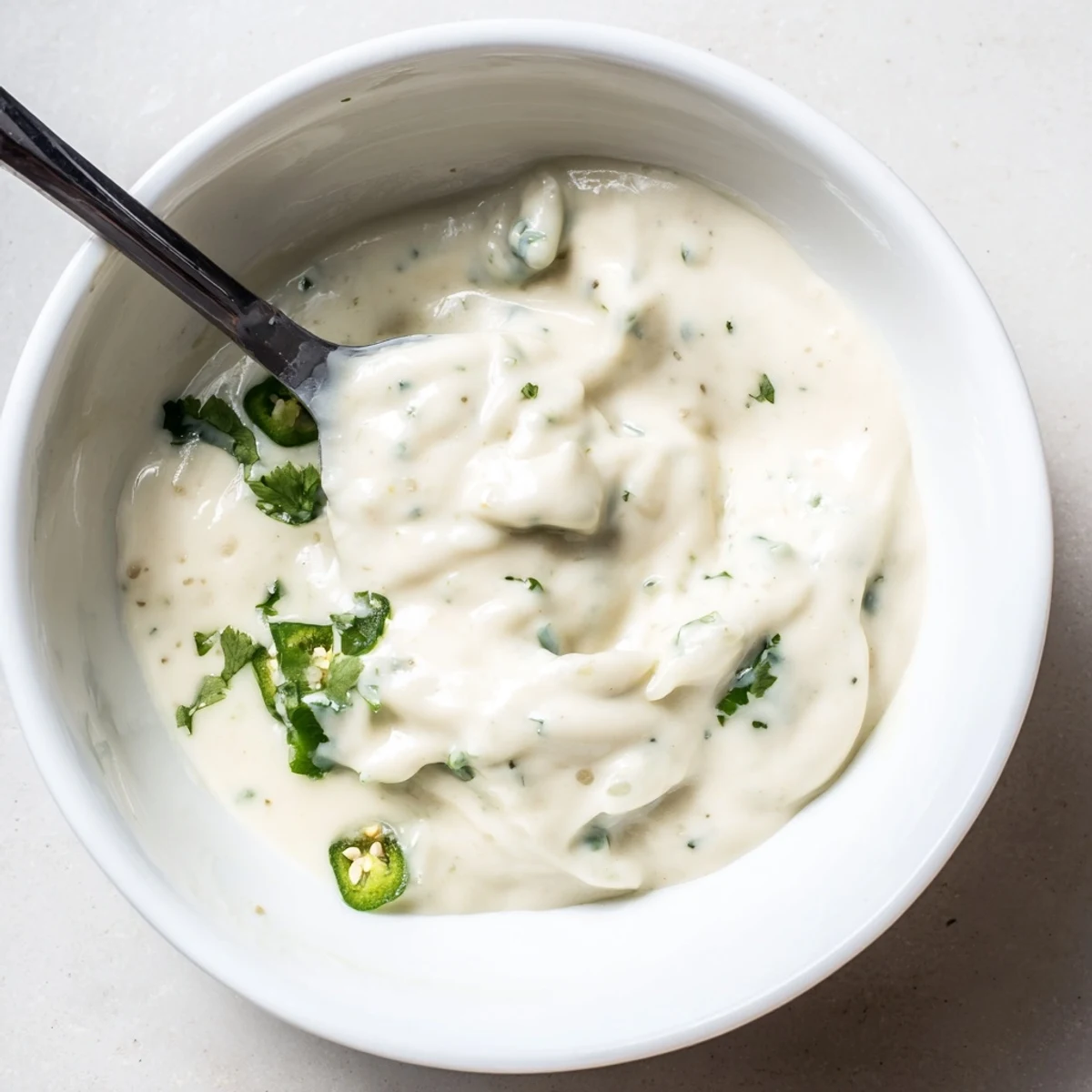 Bowl of homemade Mexican white sauce dip served with tortilla chips for appetizers