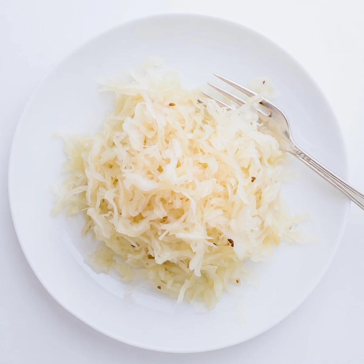 Golden fermented sauerkraut packed in glass jar with tangy shredded cabbage