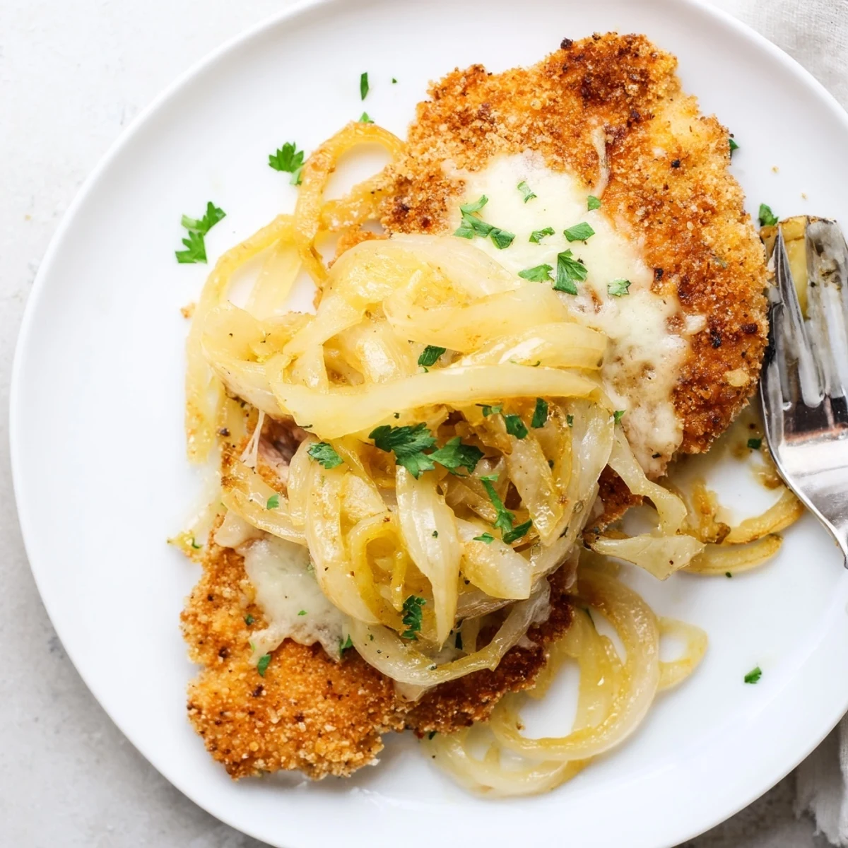 Crispy Chicken Caramelized Onions Melted Cheese on a baking sheet, bubbling and golden