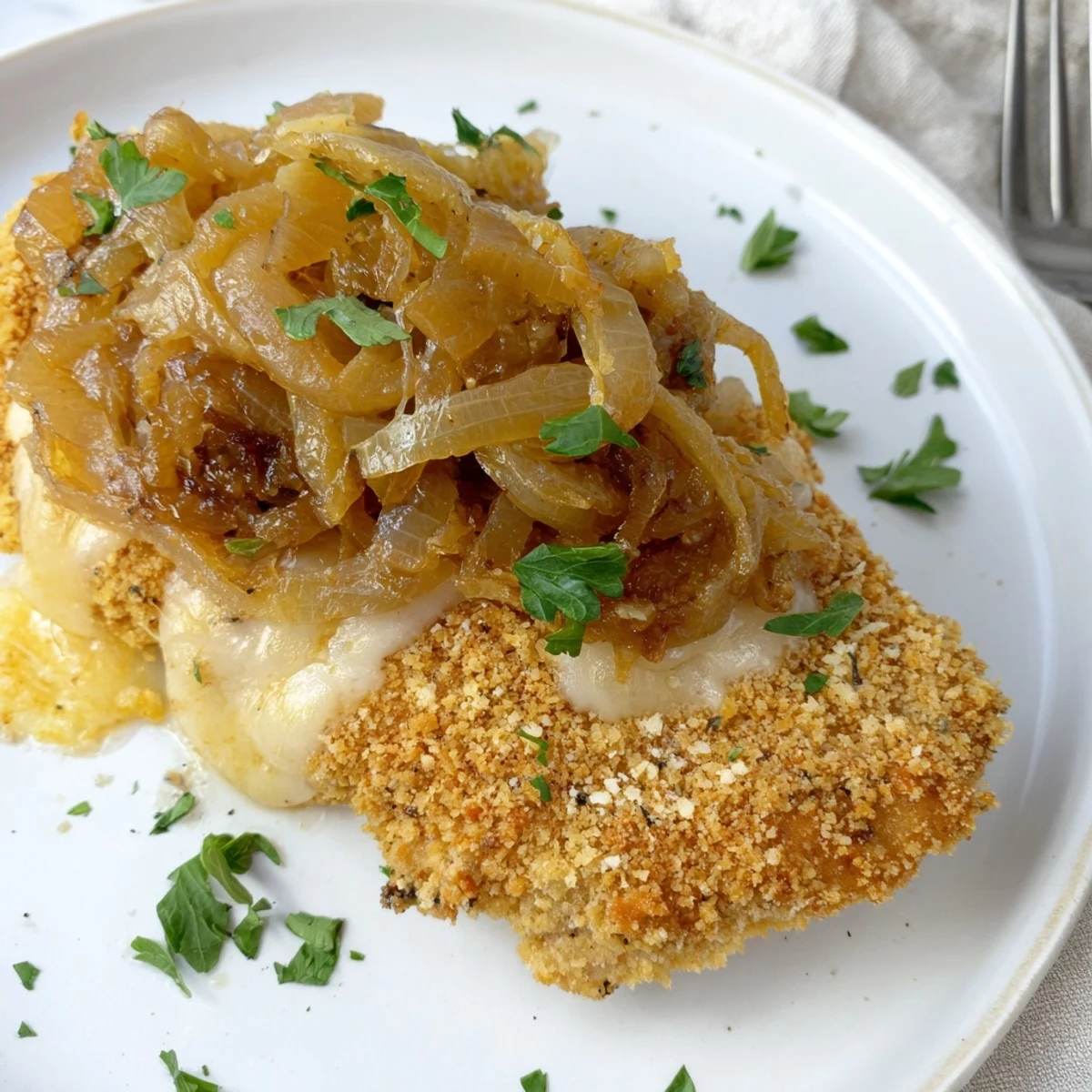 Pan-seared Crispy Chicken Caramelized Onions Melted Cheese topped with parsley, ready to serve