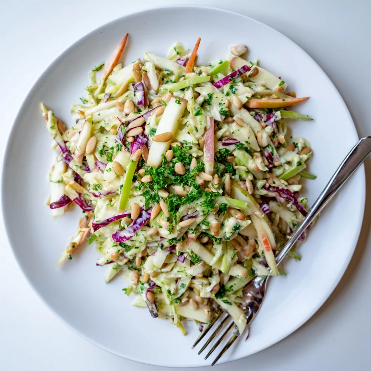Fresh apple coleslaw served in white bowl with crisp shredded cabbage and tangy honey-mustard dressing