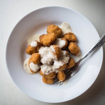 Crispy Chicken Fried Mushrooms with Gravy drizzled over mashed potatoes for a hearty dinner.